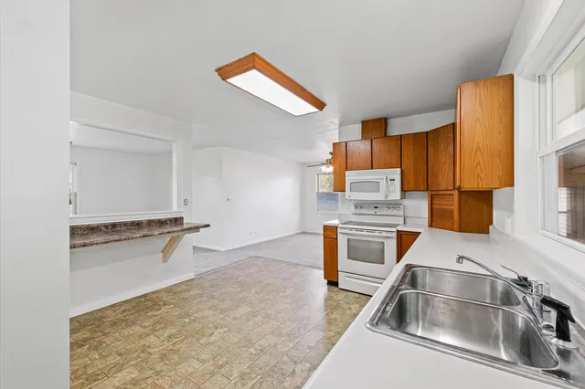 a kitchen with stainless steel appliances granite countertop a sink refrigerator and microwave