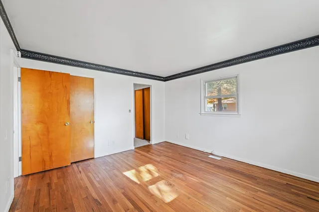 a view of empty room with wooden floor
