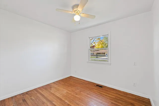 a view of room with wooden floor and ceiling fan