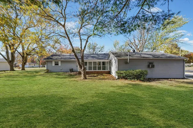 a front view of a house with a garden and trees