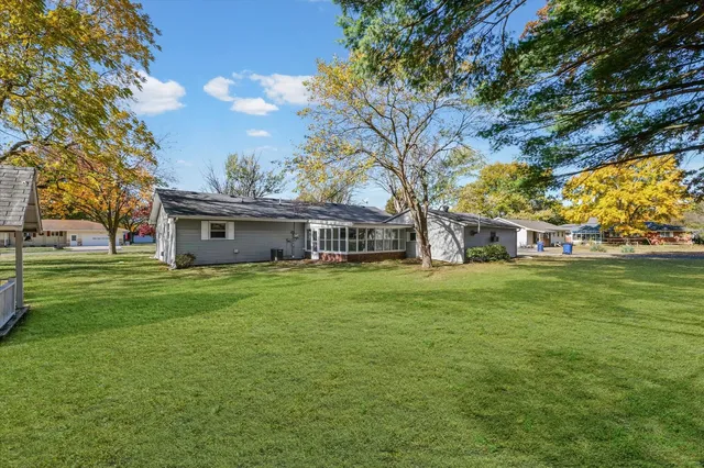 a front view of house with yard and trees in the background