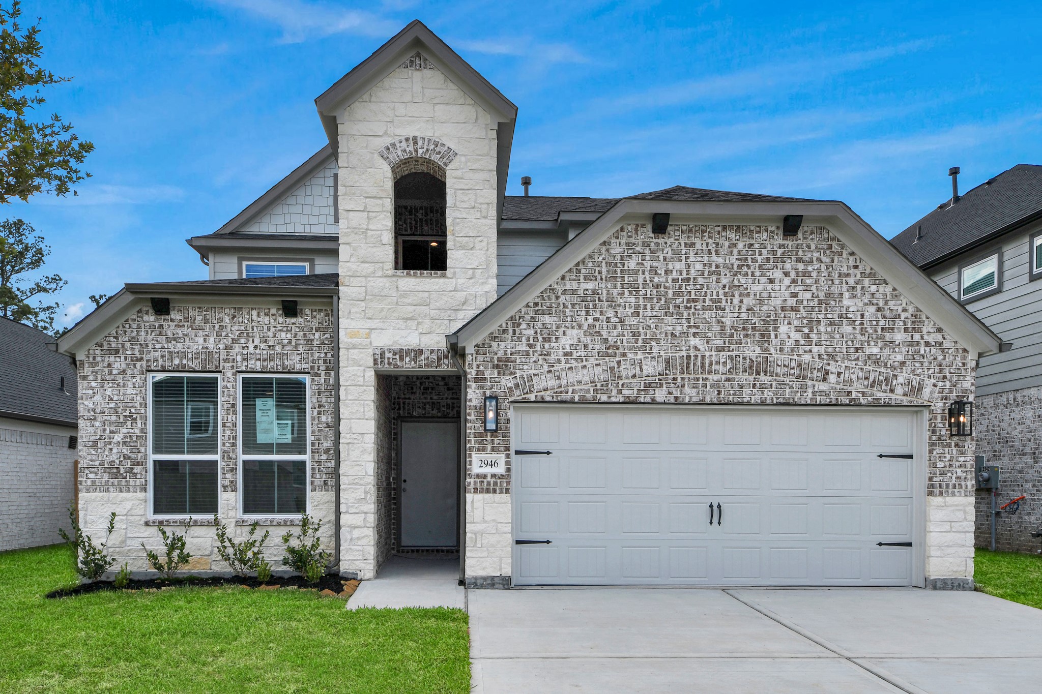 2946 Burris Park Drive Spring, TX 77373 - Photo 4 of 45 Meticulously maintained yard and lush landscape, paired with a premium elevation featuring captivating brick accents. Modern coach lights add a touch of contemporary elegance to the exterior.
