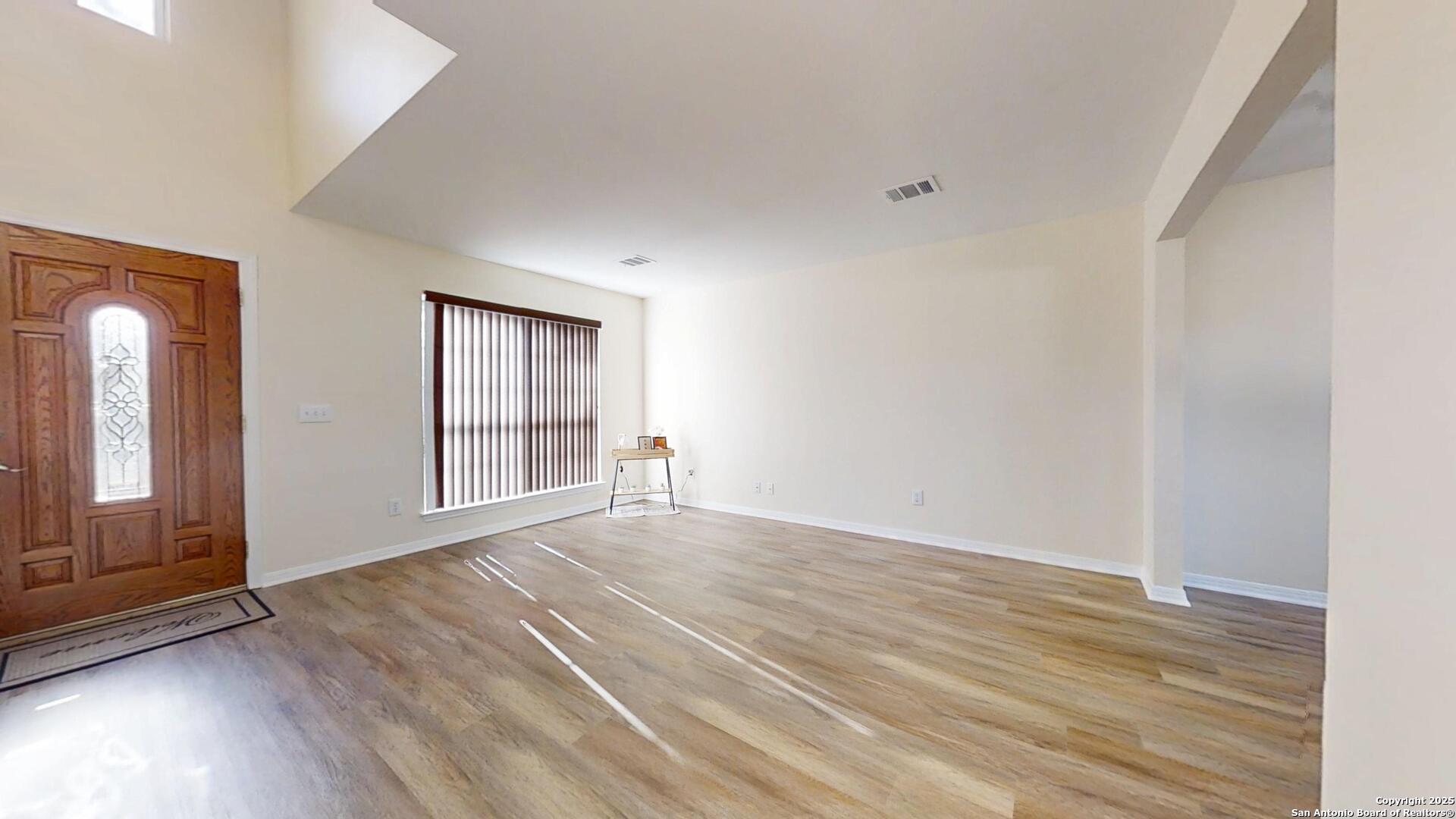10718 Mustang Ridge Converse, TX 78109 - Photo 2 of 21 a view of an empty room with wooden floor and a window