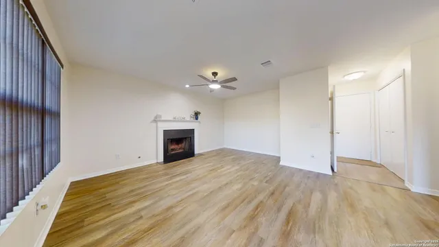 a view of an empty room with a fireplace and a window