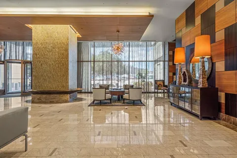a view of a hallway with wooden floor and cabinet