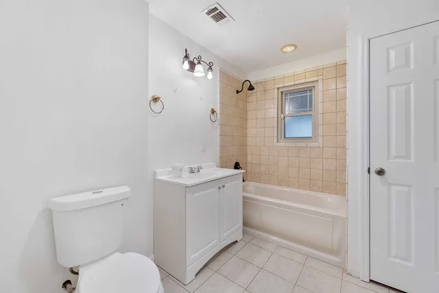 a bathroom with a granite countertop toilet a sink and bathtub
