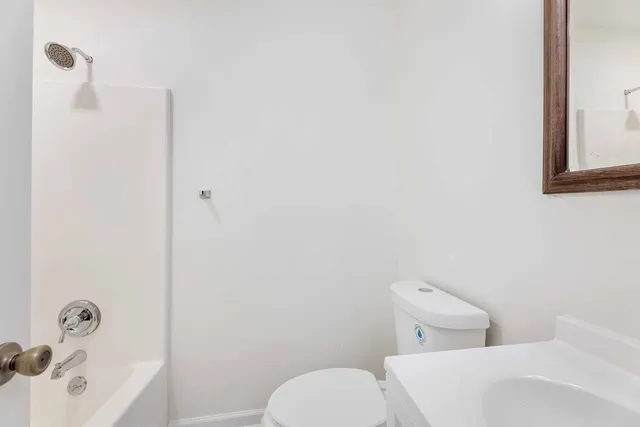a white toilet sitting next to a bathroom sink