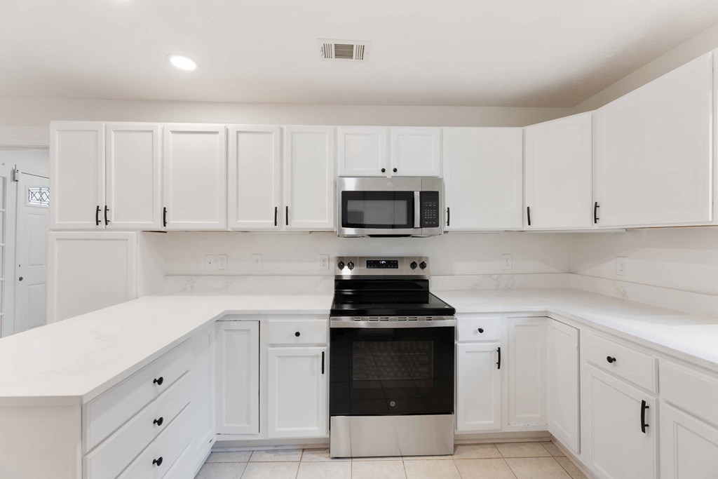 322 Moores Chapel Road Mauk, GA 31058 - Photo 9 of 34 a kitchen with white cabinets and black appliances