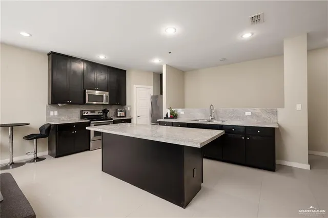 a kitchen with granite countertop a sink dishwasher stove and cabinets