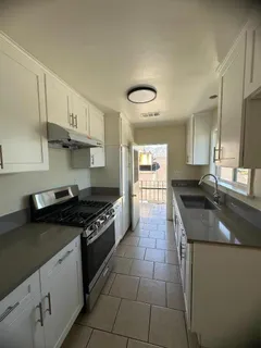 a stove top oven sitting inside of a kitchen
