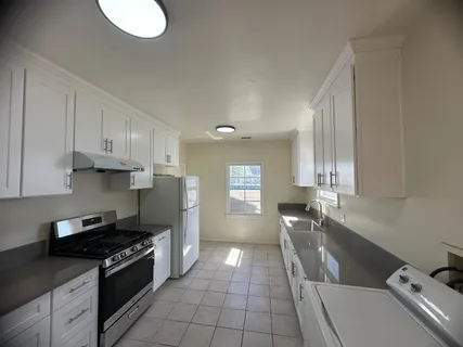 a kitchen with a sink a stove and cabinets
