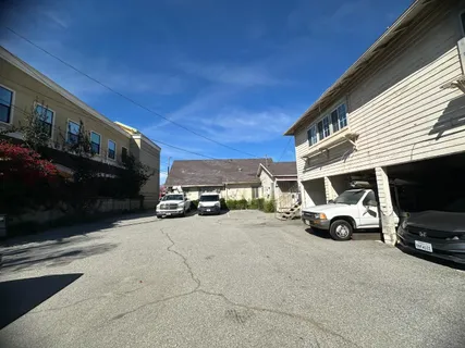 a view of a house with a large space and a car parked in front of it