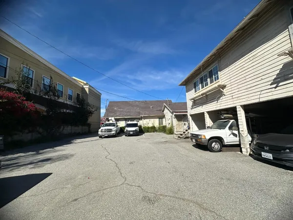 a view of a house with a large space and a car parked in front of it