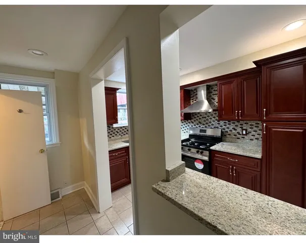 a kitchen with stainless steel appliances granite countertop a refrigerator and a stove top oven