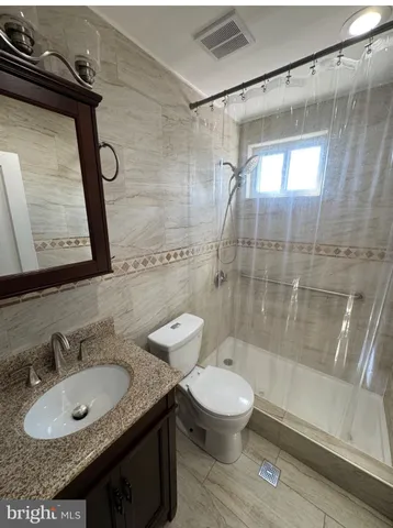 a bathroom with a granite countertop sink toilet and shower
