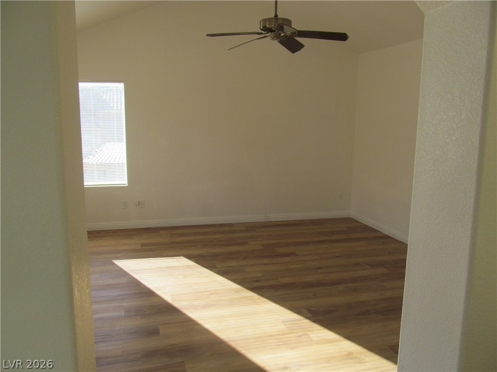 8701 Crescent Ridge Lane Las Vegas, NV 89134 - Photo 19 of 28 A quiet room featuring vaulted ceilings and inviting wood flooring.