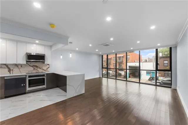 a view of kitchen with stainless steel appliances granite countertop a stove top oven a sink and a microwave