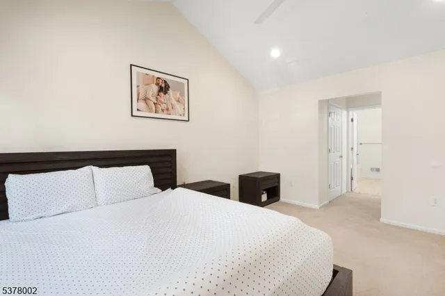 a bedroom with a large bed and a lamp on table