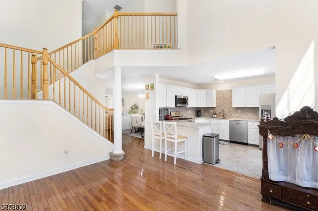 a living room with kitchen island a dining table wooden floor and a fireplace