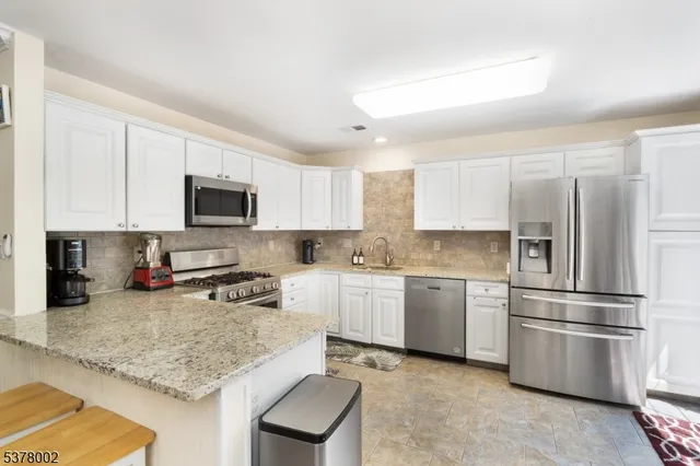 a kitchen with a refrigerator a microwave a sink and cabinets