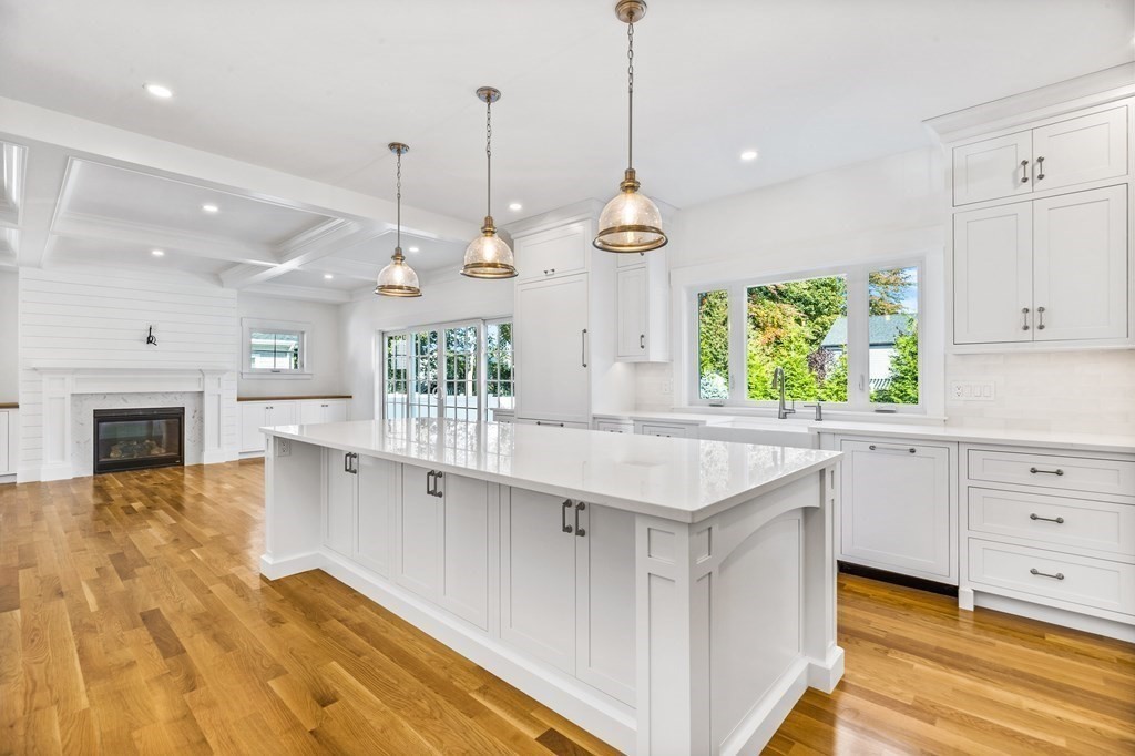 40 Foley Beach Road Hingham, MA 02043 - Photo 4 of 37 a kitchen with kitchen island granite countertop a stove a oven a dining table and chairs with wooden floor