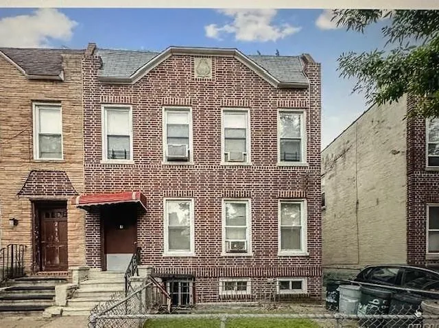 front view of a brick house with a yard