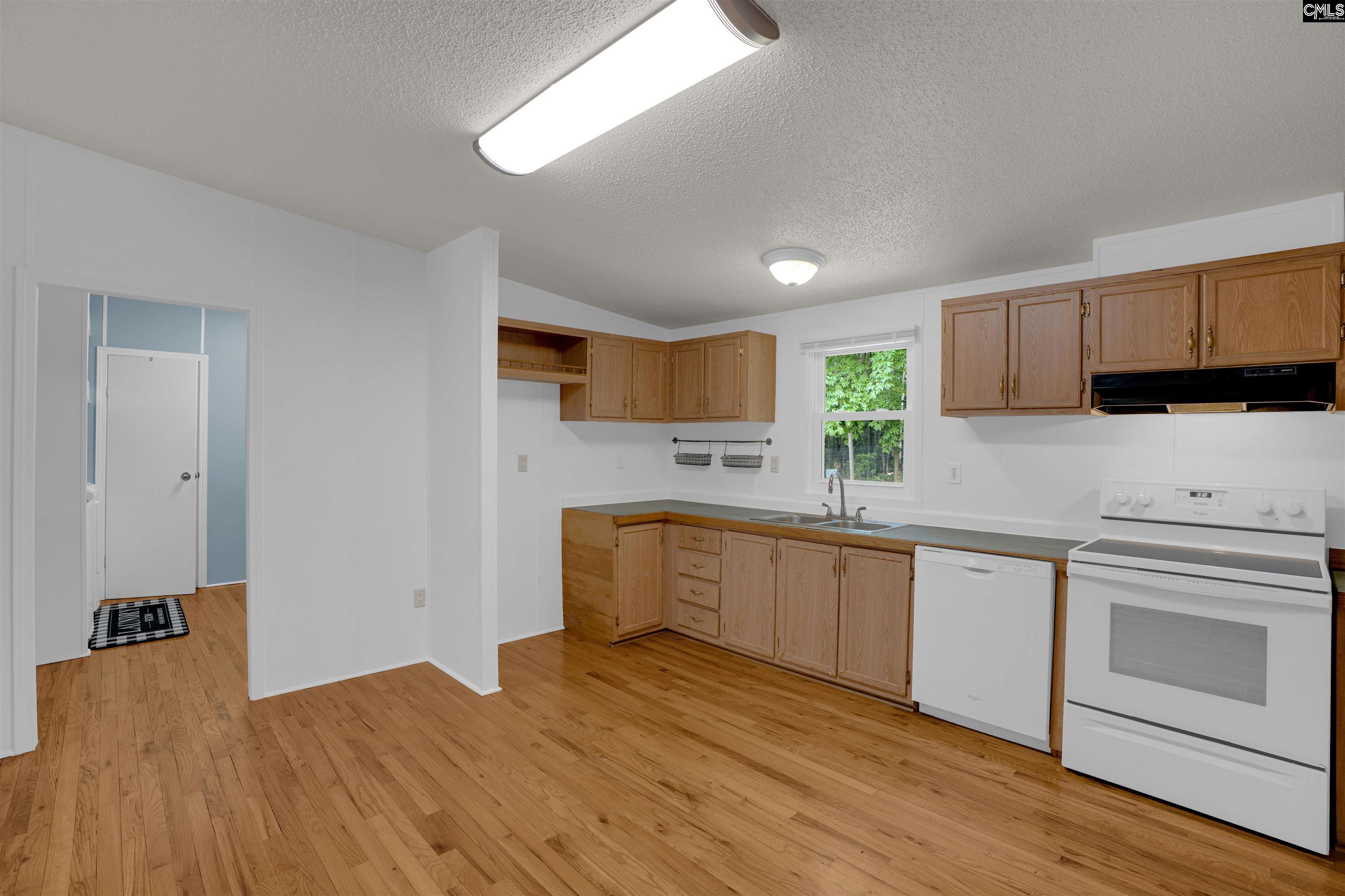 304 Cooper Road Blythewood, SC 29016 - Photo 9 of 29 a kitchen with granite countertop a stove a sink and a refrigerator