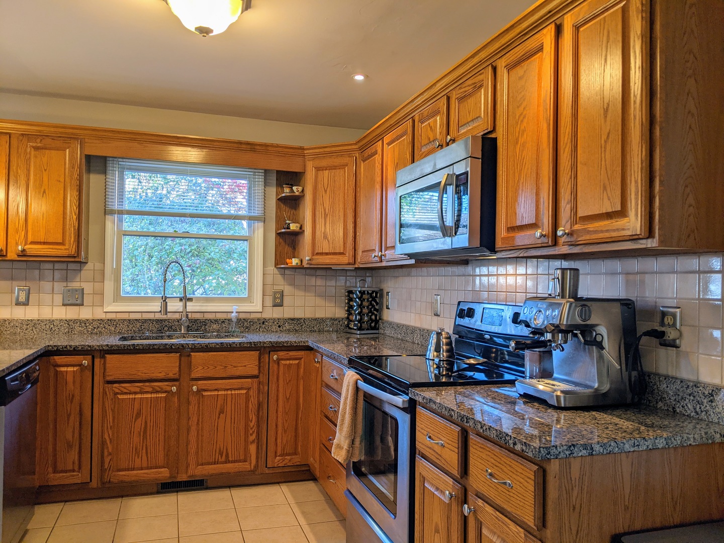 1409 Cobblefield Road Champaign, IL 61822 - Photo 28 of 73 a kitchen with stainless steel appliances granite countertop wooden cabinets a window and a sink