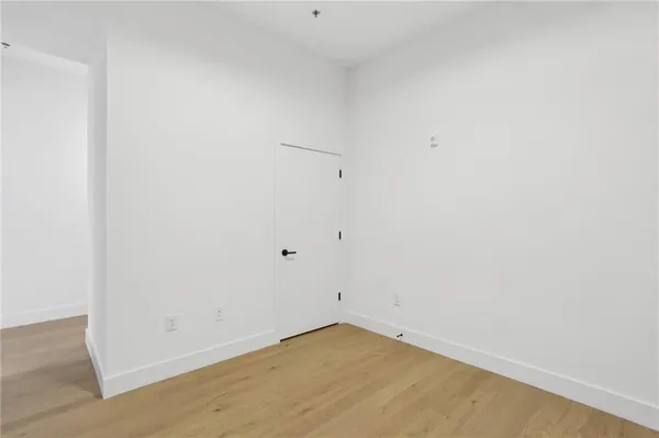 a view of room with wooden floor and mirror