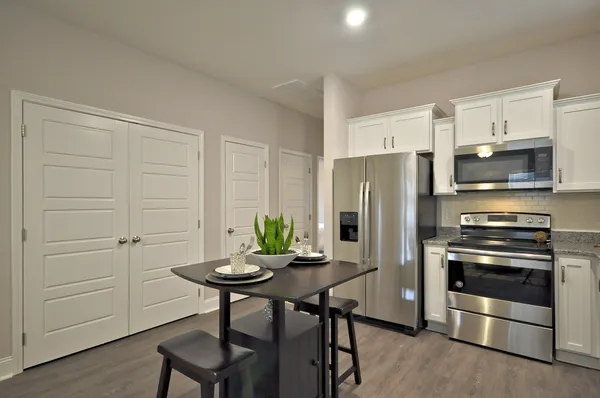 a kitchen with stainless steel appliances a refrigerator a stove a chimney and a center island