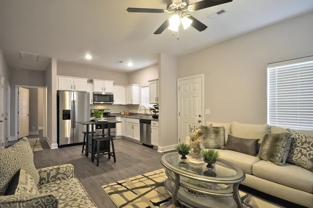 a living room with furniture kitchen view and a window