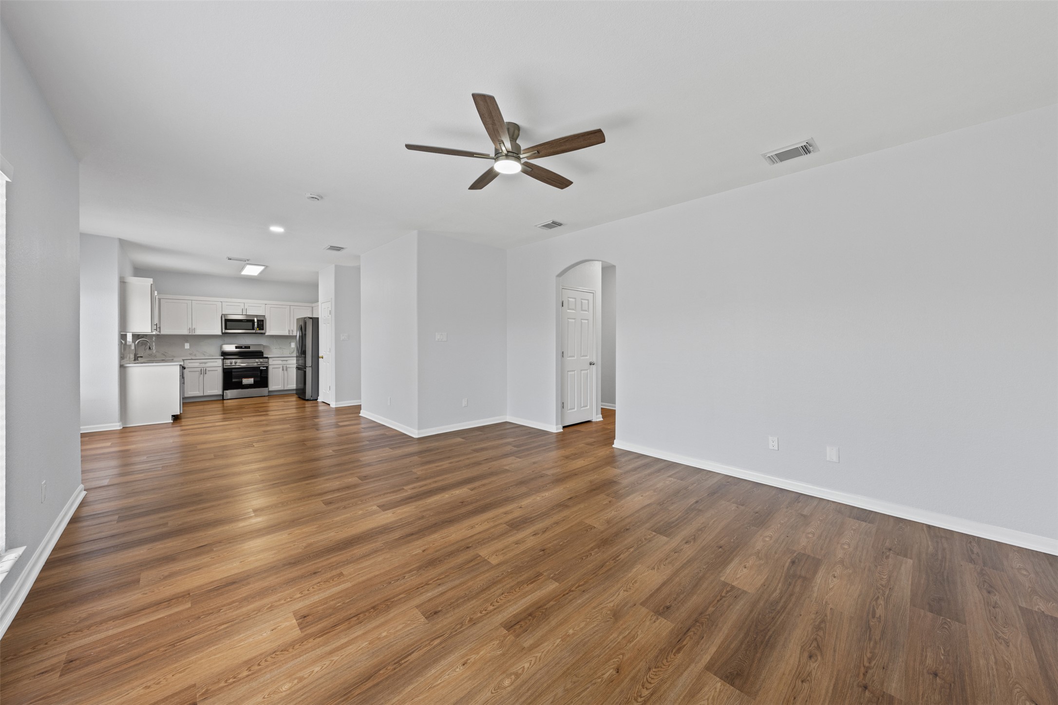 243 Engineers Pass Jarrell, TX 76537 - Photo 12 of 40 Expansive living area featuring wood-finish flooring, a ceiling fan, and a neutral color palette