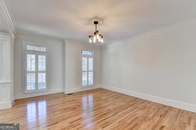 a view of an empty room with wooden floor and a fireplace