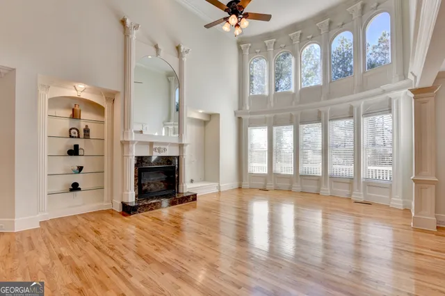 a living room with fireplace furniture and a ceiling fan