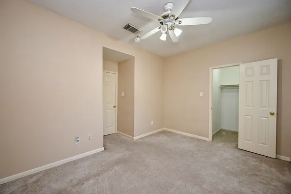 an empty room with a ceiling fan and a window