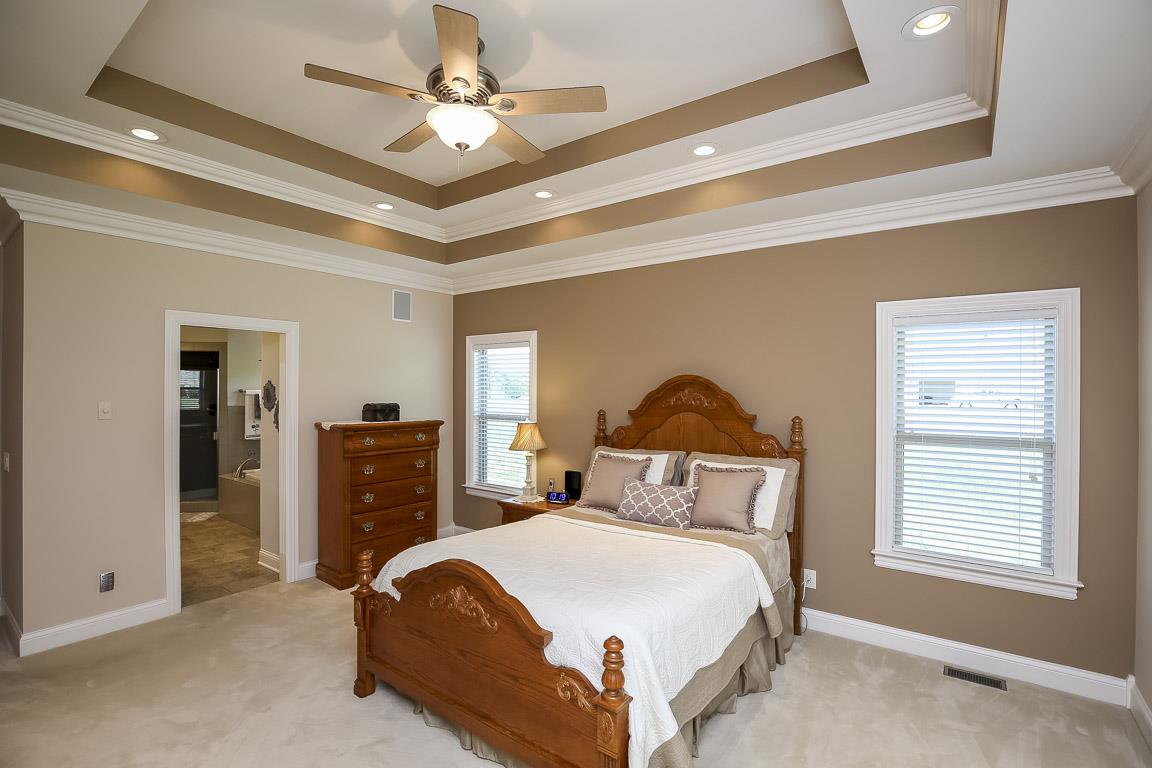 223 Butler Bridge Road Portland, TN 37148 - Photo 18 of 30 a bedroom with a bed and a chandelier
