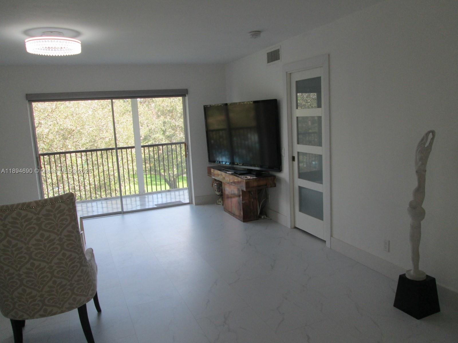 150 South Hollybrook Terrace, Unit 303 Pembroke Pines, FL 33025 - Photo 11 of 18 a living room with furniture and a flat screen tv
