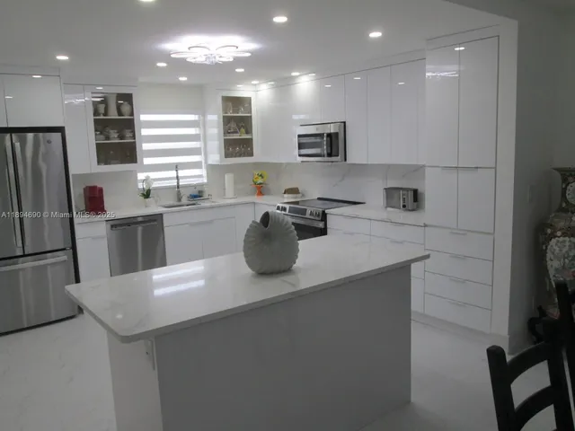 a kitchen with a sink a refrigerator and cabinets