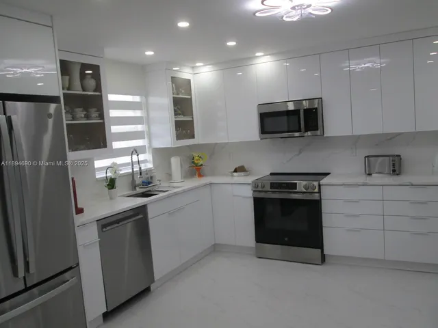 a kitchen with stainless steel appliances a sink stove and refrigerator