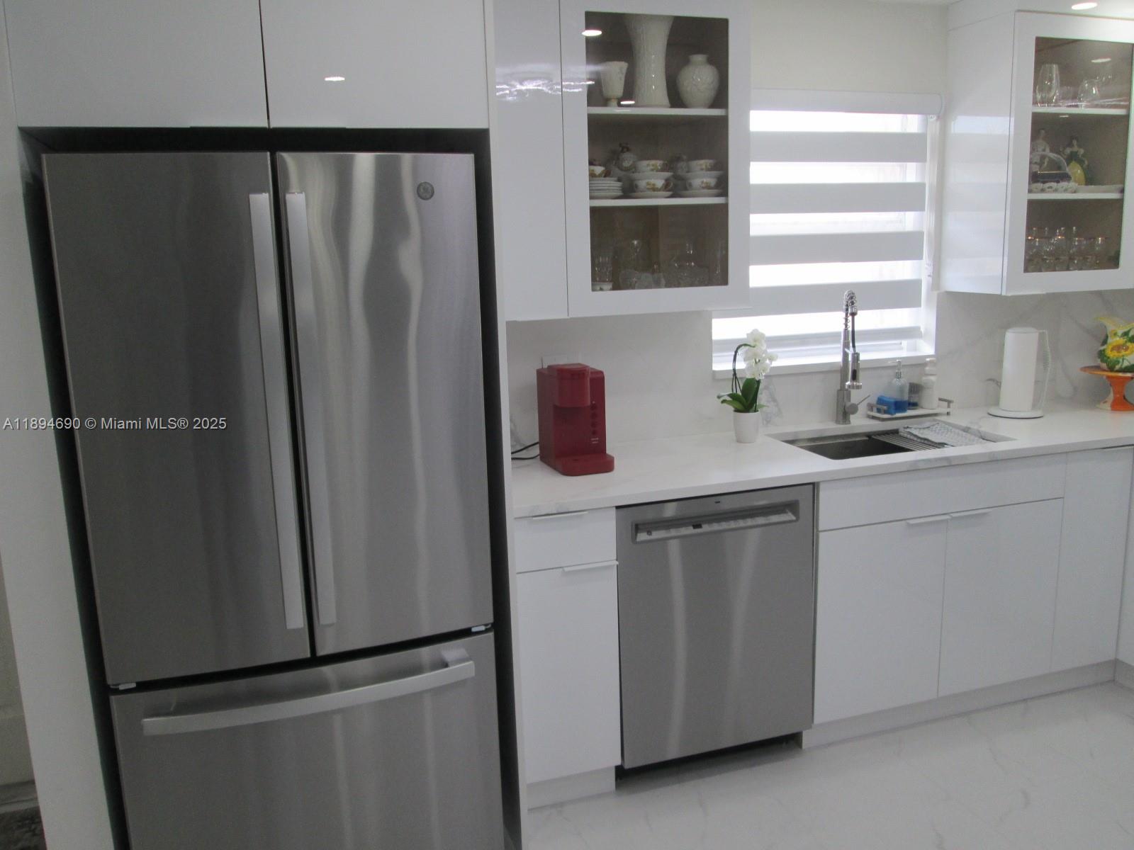 150 South Hollybrook Terrace, Unit 303 Pembroke Pines, FL 33025 - Photo 6 of 18 a kitchen with a refrigerator and a sink