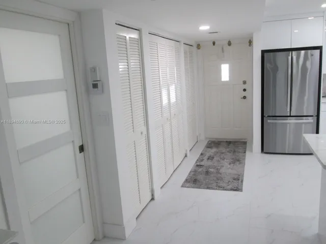 a view of a hallway with a refrigerator