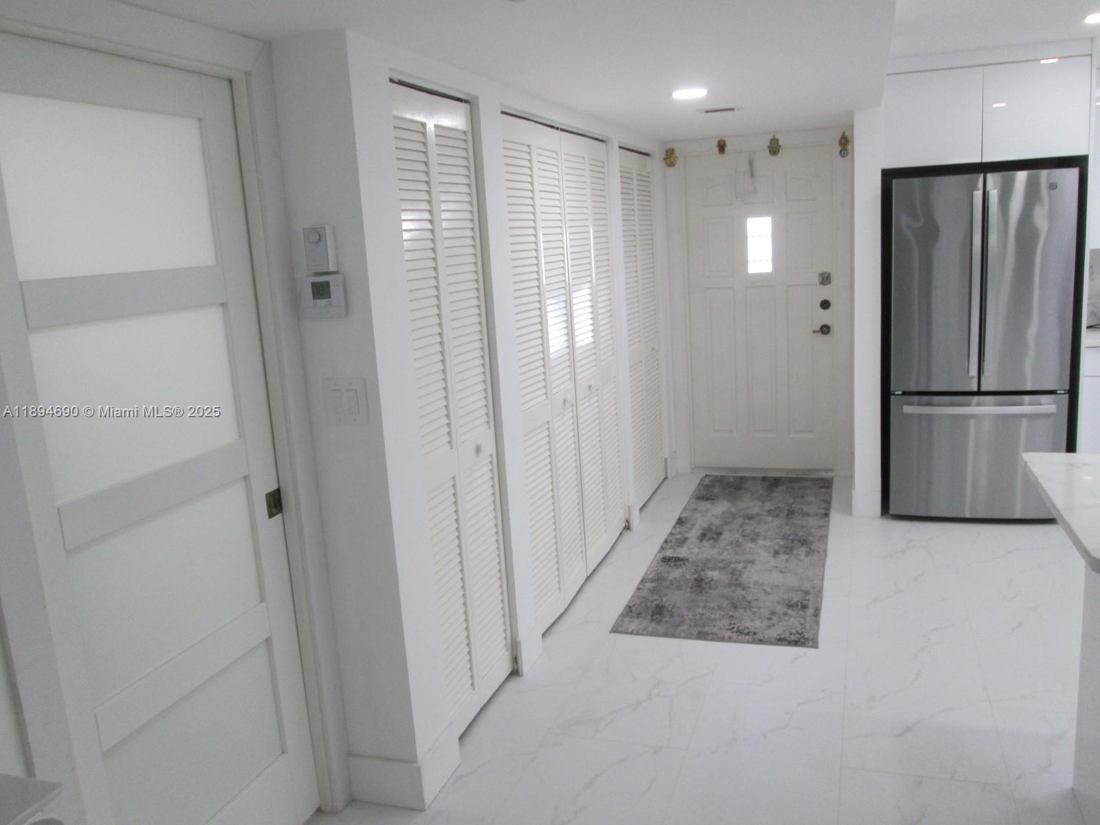 150 South Hollybrook Terrace, Unit 303 Pembroke Pines, FL 33025 - Photo 7 of 18 a view of a hallway with a refrigerator