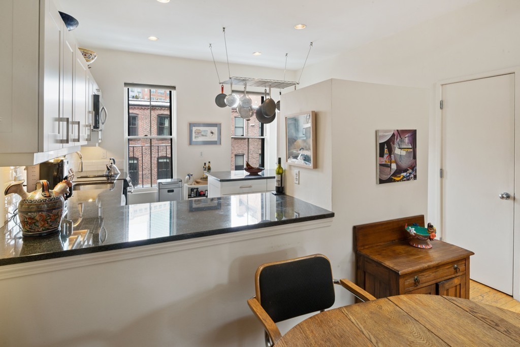 103 Appleton Street, Unit 4 Boston, MA 02116 - Photo 3 of 29 a kitchen with stainless steel appliances granite countertop a sink dishwasher a refrigerator and wooden cabinets