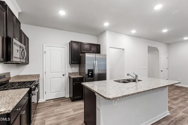 a kitchen with a center island and stainless steel appliances