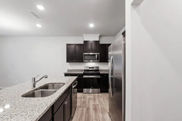 a kitchen with granite countertop a sink and steel appliances