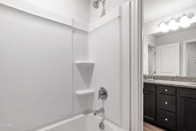 a bathroom with a granite countertop sink a toilet and bathtub