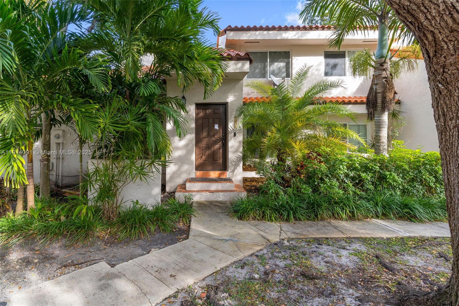10930 Southwest 75th Street Miami, FL 33173 - Photo 1 of 34 a front view of a house with garden