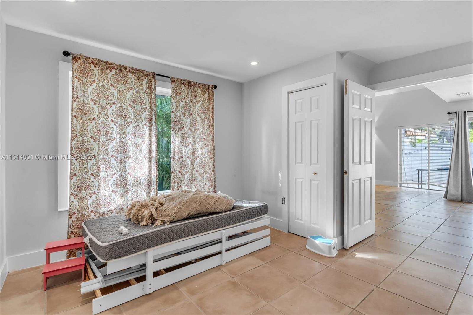10930 Southwest 75th Street Miami, FL 33173 - Photo 11 of 34 a spacious bedroom with a bed and large window