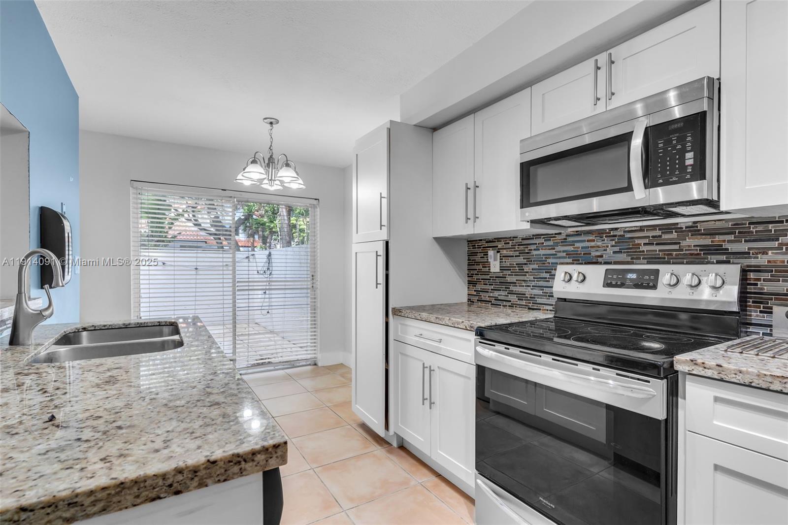 10930 Southwest 75th Street Miami, FL 33173 - Photo 12 of 34 a kitchen with granite countertop a stove oven and a sink