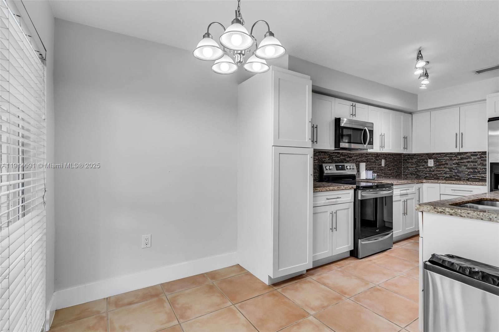 10930 Southwest 75th Street Miami, FL 33173 - Photo 13 of 34 a kitchen with stainless steel appliances granite countertop a refrigerator a stove top oven a sink and dishwasher